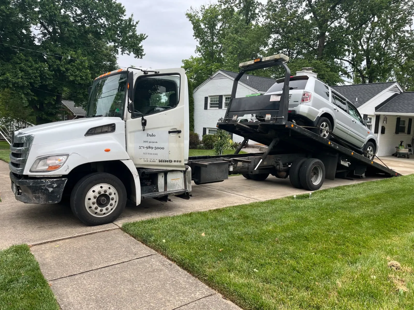 Dalo Auto Recycling flatbed tow truck loading a residential SUV in Burke, VA