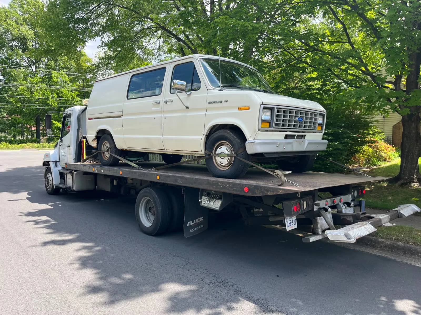 Older van loaded onto a Dalo Auto Recycling flatbed truck during a Dumfries, VA vehicle pickup