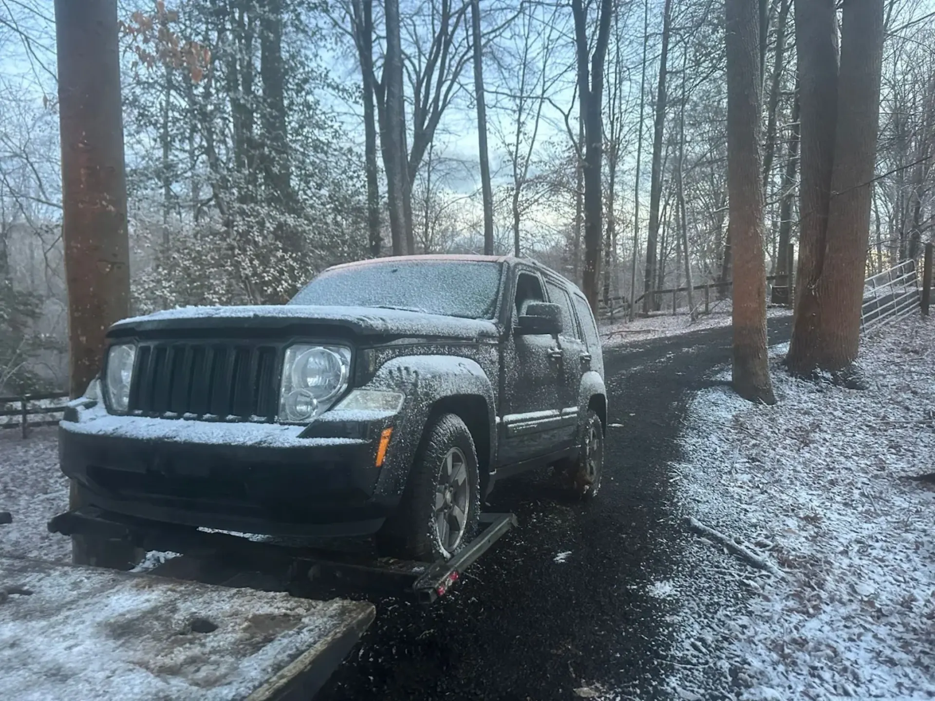 Non-running SUV loaded onto a Dalo Auto Recycling flatbed truck during winter conditions in Northern Virginia