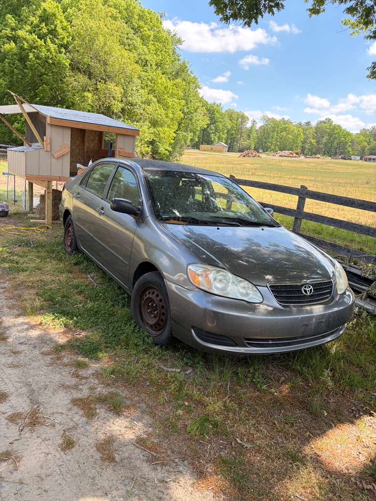 Older Toyota Corolla sitting in a Virginia yard after years without current title paperwork